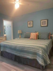a bedroom with a large bed with a striped blanket at Wanderlust Villa only 3 min walk to the Sand! in Panama City Beach