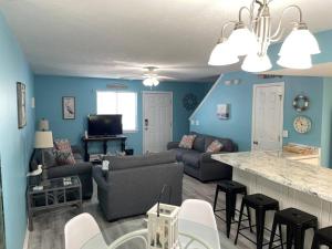 a living room with blue walls and a couch and a table at Wanderlust Villa only 3 min walk to the Sand! in Panama City Beach