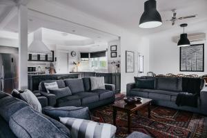 a living room with two couches and a kitchen at York House Daylesford in Daylesford