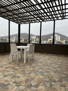 a table and chairs on a balcony with a view of a city at la florida C in Salta
