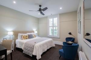 a bedroom with a bed and a blue chair at The Lord Clyde in Clyde