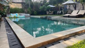 a swimming pool in a backyard with a pool at Homestay Pelangi Jimbaran in Jimbaran