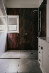 a bathroom with a shower and a tile floor at York House Daylesford in Daylesford