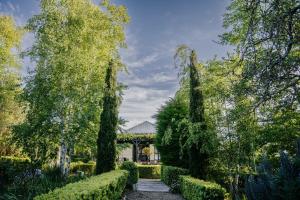 a garden with trees and a house in the background at York House Daylesford in Daylesford