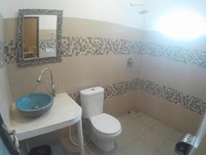 a bathroom with a toilet and a sink and a mirror at Canggu Pinpoint Rooms in Canggu