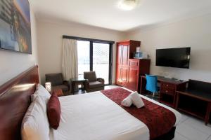 a hotel room with a bed and a desk and a television at Coffee House Apartment Motel in Rockhampton