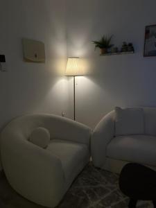 a living room with a couch and a chair and a lamp at شقة مودرن حي الروضة in Jeddah