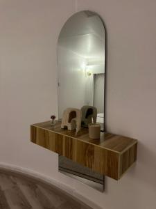 a bathroom with a mirror and a wooden shelf at شقة مودرن حي الروضة in Jeddah