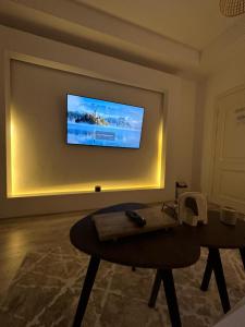 a living room with a table and a television on a wall at شقة مودرن حي الروضة in Jeddah