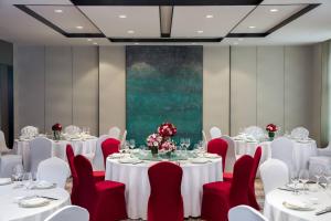 a conference room with white tables and red chairs at Courtyard by Marriott Tianjin Hongqiao in Tianjin