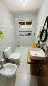 a bathroom with a toilet and a sink at Quarto Sertão no Mar in Barra do Cunhau