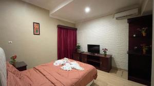 a hotel room with a bed and a television at Homestay Pelangi Jimbaran in Jimbaran