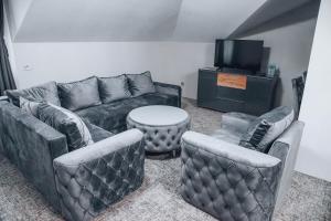 uma sala de estar com sofás, uma mesa e uma televisão em S Club Resort Hotel Aqua Park and Spa em Belgrado