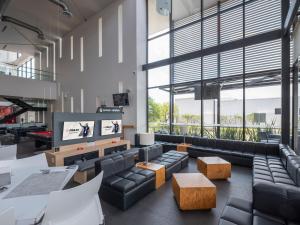Habitación grande con sofás y TV de pantalla plana. en Ramada Encore by Wyndham Aguascalientes, en Aguascalientes
