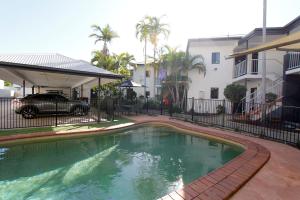 a swimming pool in front of a building at Coffee House Apartment Motel in Rockhampton