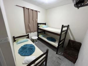 a small room with two bunk beds and a table at Pousada da Praia in São Vicente