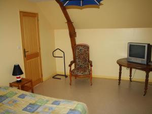 a bedroom with a bed and a chair and a tv at Gîte Saint-Rémy-de-Sillé, 6 pièces, 8 personnes - FR-1-410-150 in Saint-Rémy-de-Sillé