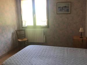 1 dormitorio con 1 cama, 1 silla y 1 ventana en Gîte Marolles-les-Braults, 4 pièces, 7 personnes - FR-1-410-136, en Marolles-les-Braults