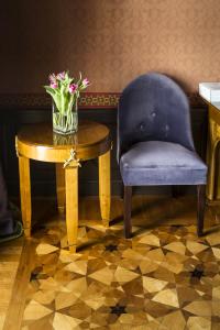 a blue chair and a table with a vase of flowers at Villa Cora in Florence