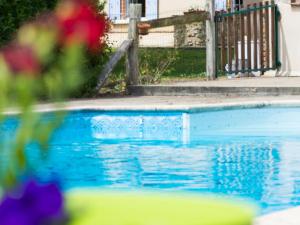 una piscina con acqua blu di fronte a una casa di Gîte Thorée-les-Pins, 4 pièces, 7 personnes - FR-1-410-390 a Thorée-les-Pins