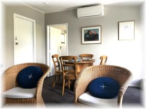 Pukerua Bay的住宿－Peaceful Pukerua Bay，用餐室配有藤椅和桌子