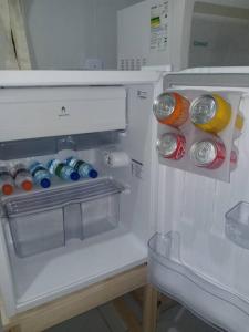 an open refrigerator with bottles and cans of soda at Hospede-se no IPSEP , em Recife , próximo ao Aeroporto Internacional dos Guararapes in Recife +13 photos