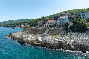 Apartments by the sea Prigradica, Korcula - 248 في Blato: مجموعة منازل في جزيرة صخرية في الماء