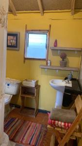 a bathroom with a sink and a toilet and a window at CABAÑA JACARANDA in Horcon