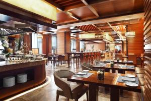 a restaurant with wooden tables and chairs and a bar at Sheraton Wenzhou Hotel in Wenzhou