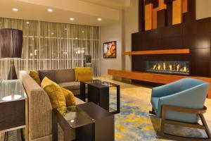 a living room with a couch and a fireplace at Courtyard Omaha La Vista in La Vista