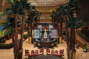 un casino intérieur avec des palmiers dans un centre commercial dans l'établissement Renaissance Tianjin TEDA Convention Centre Hotel, à Binhai