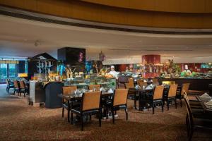 um restaurante com mesas e cadeiras e um bar em Renaissance Tianjin TEDA Convention Centre Hotel em Binhai