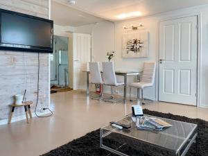 uma sala de estar com uma mesa e cadeiras e uma televisão de ecrã plano em Unique 3bed Rooms - Generous Terrace - Central Stavanger em Stavanger