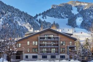 un edificio en la nieve con montañas en el fondo en W Aspen en Aspen