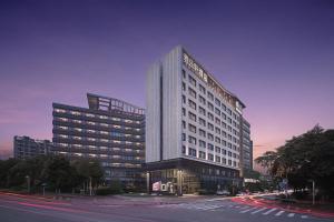 a rendering of a tall building in a city at Aloft Guangzhou University Park in Guangzhou