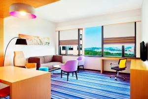 a living room with a couch and chairs at Aloft Guangzhou University Park in Guangzhou