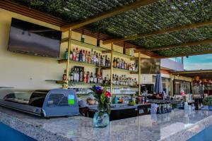a bar in a restaurant with a counter with flowers at Morgan Hotel Boutique & Residences, Los Cabos in Cabo San Lucas