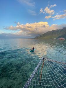 a person on a paddle board in the water at Ora Sunrise View in Kaloa