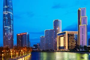 eine Skyline der Stadt mit hohen Gebäuden und einem Fluss in der Unterkunft The St. Regis Tianjin in Tianjin