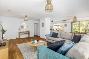 a living room with a couch and a table at Ocean Bay Retreat - Relish in Gorgeous Beachy Style in Rye