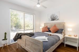 a bedroom with a large bed and a window at Ocean Bay Retreat - Relish in Gorgeous Beachy Style in Rye