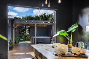 een keuken met een houten tafel en uitzicht op een achtertuin bij The Black Barn in Auckland