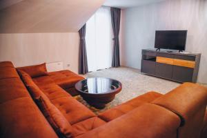 a living room with a couch and a television at S Club Resort Hotel Aqua Park and Spa in Belgrade