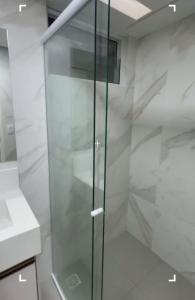 a glass shower in a bathroom with white walls at Apartamento beira mar in João Pessoa