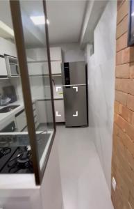 a small kitchen with a refrigerator and a stove at Apartamento beira mar in João Pessoa