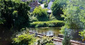 a bench sitting on a bridge over a river at Slaney Suites in Enniscorthy