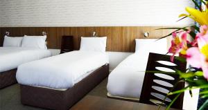 two beds in a hotel room with flowers at Slaney Suites in Enniscorthy