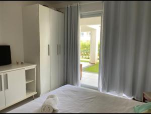 um quarto com uma cama e uma porta de vidro deslizante em Apartamento Master VIP com 3 suítes noTree Bies Resort em Subaúma