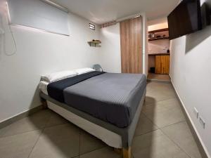 1 dormitorio con 1 cama en una habitación pequeña en Casa hotel Los Laureles, en Medellín