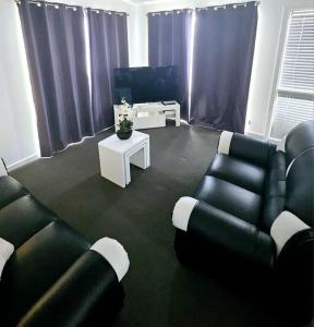 a living room with two couches and a table at San Remo Coastal Apartment in San Remo